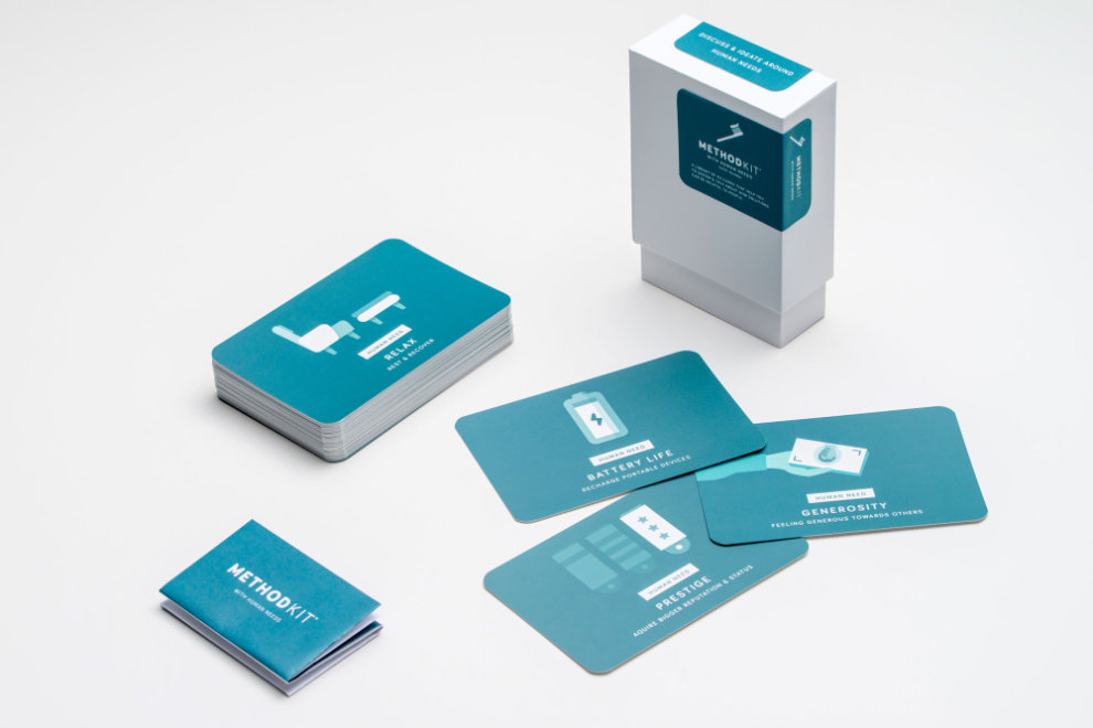 Photograph of a 'Human need' card deck from MethodKit showing the box and a few of the 'need' cards such as 'generosity', 'battery' and 'prestige'.