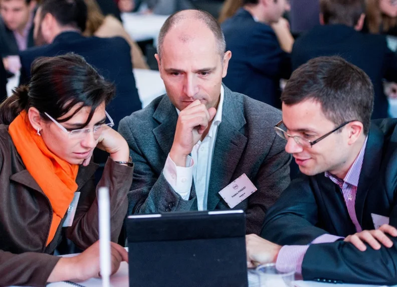 People discussing while facing an iPad