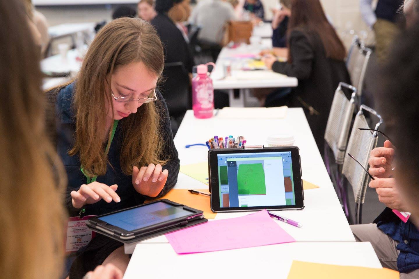 A young woman taking notes on an iPad