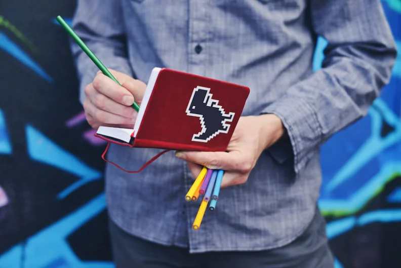 A person taking notes on a pad while standing